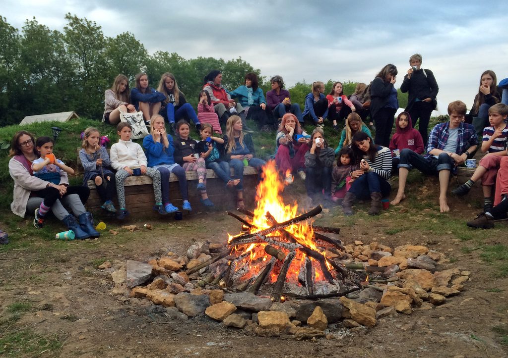 children and adults at campfire